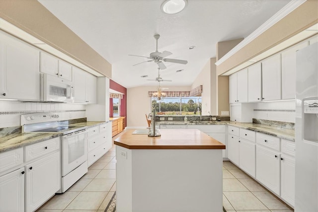 kitchen with light tile patterned floors, white appliances, a sink, and butcher block counters