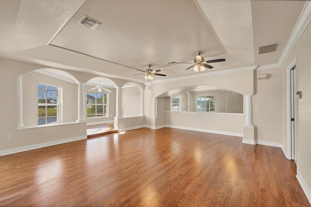 unfurnished living room featuring visible vents, ornate columns, and wood finished floors