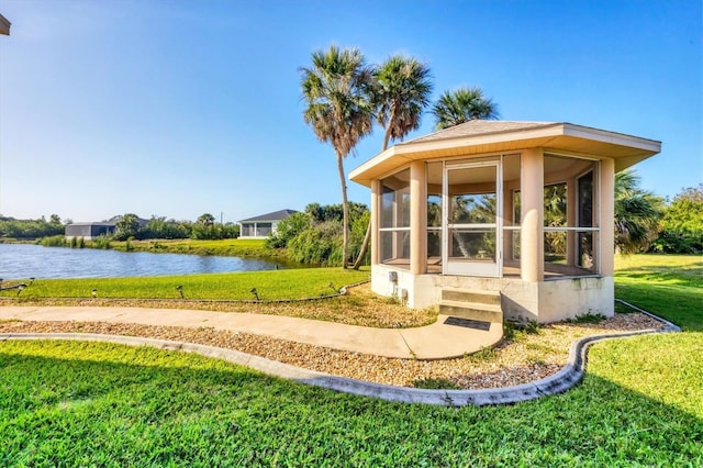 view of outdoor structure with a water view and a sunroom