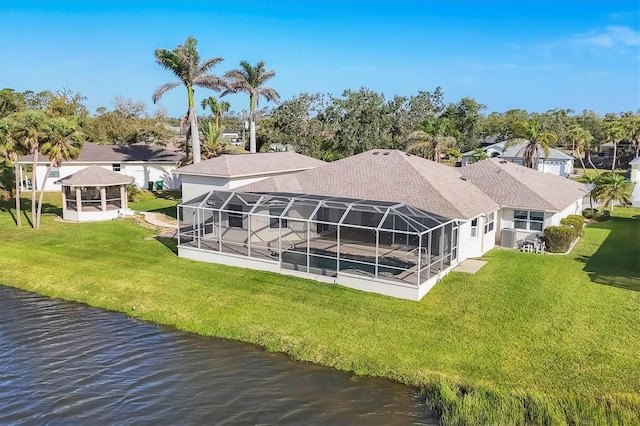 back of property with a gazebo, a yard, a water view, and a lanai