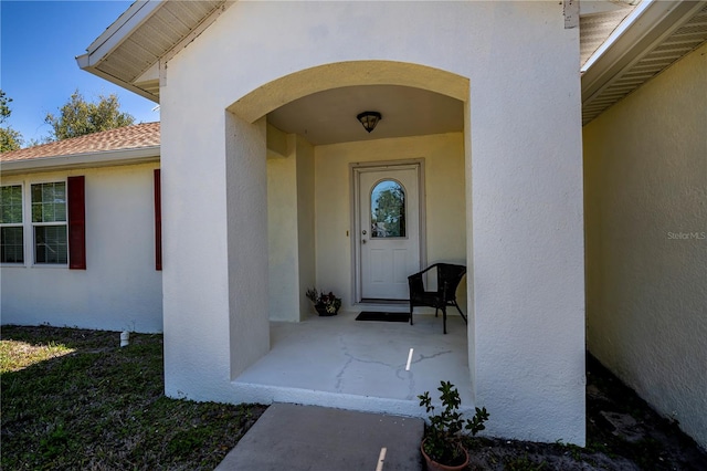 property entrance with stucco siding