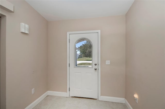 foyer entrance featuring baseboards and light tile patterned flooring