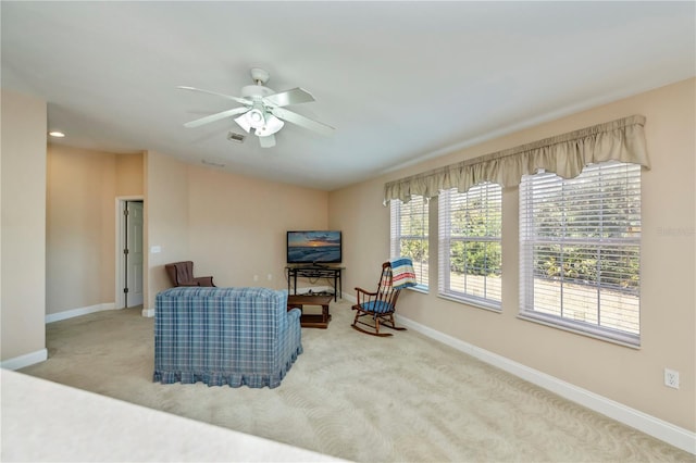 sitting room with carpet flooring, baseboards, visible vents, and a ceiling fan