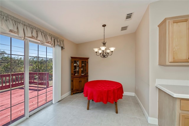 dining room with a notable chandelier, light tile patterned flooring, and baseboards