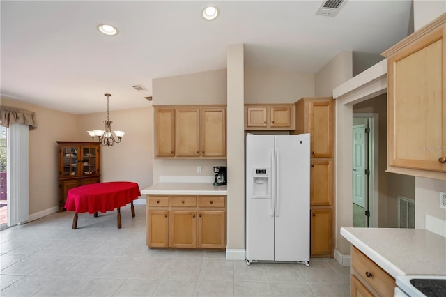 kitchen featuring visible vents, light brown cabinetry, light countertops, white refrigerator with ice dispenser, and a notable chandelier