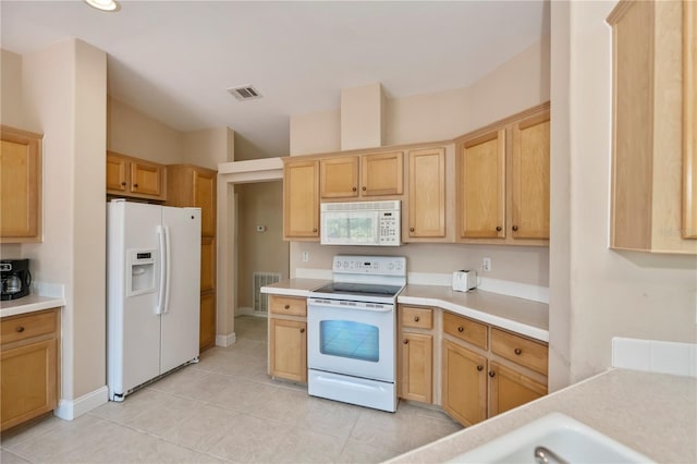 kitchen featuring white appliances, light countertops, visible vents, and light brown cabinets