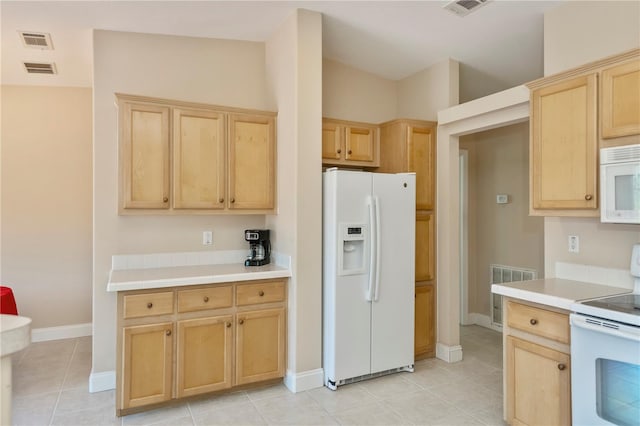 kitchen with visible vents, white appliances, light brown cabinets, and light countertops