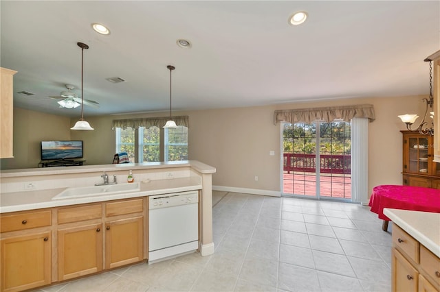 kitchen featuring a healthy amount of sunlight, dishwasher, light countertops, and a sink