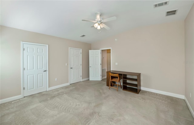 unfurnished bedroom featuring visible vents, baseboards, and lofted ceiling