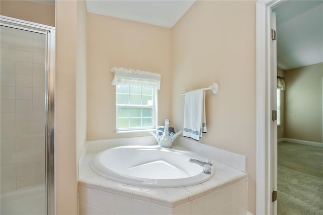 bathroom featuring a shower stall and a bath