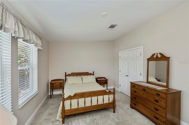 bedroom featuring baseboards, visible vents, and light carpet