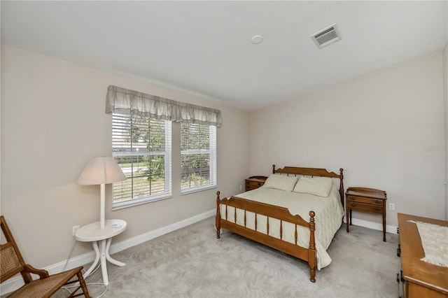 bedroom featuring baseboards, visible vents, and light carpet