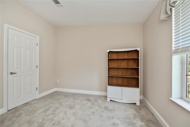 unfurnished bedroom with carpet, visible vents, and baseboards