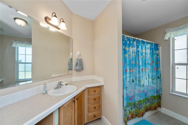 bathroom with tile patterned flooring, vanity, a shower with shower curtain, and baseboards