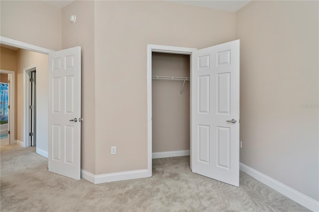 unfurnished bedroom with a closet, baseboards, and carpet flooring