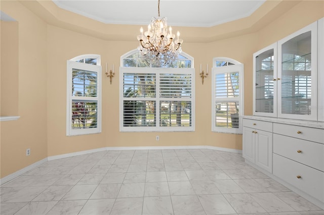 unfurnished dining area with crown molding, baseboards, an inviting chandelier, marble finish floor, and a raised ceiling