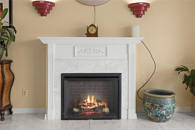 interior details featuring baseboards and a tiled fireplace