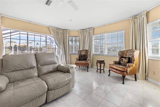 living area featuring a ceiling fan, visible vents, a sunroom, and baseboards