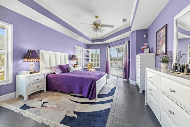 bedroom with access to exterior, visible vents, baseboards, and a raised ceiling