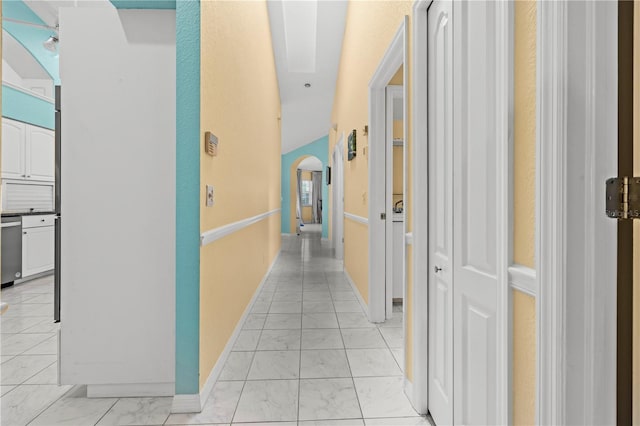 corridor with baseboards, arched walkways, and marble finish floor