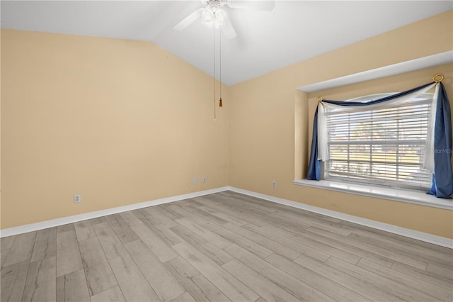 spare room featuring baseboards, lofted ceiling, wood finished floors, and a ceiling fan