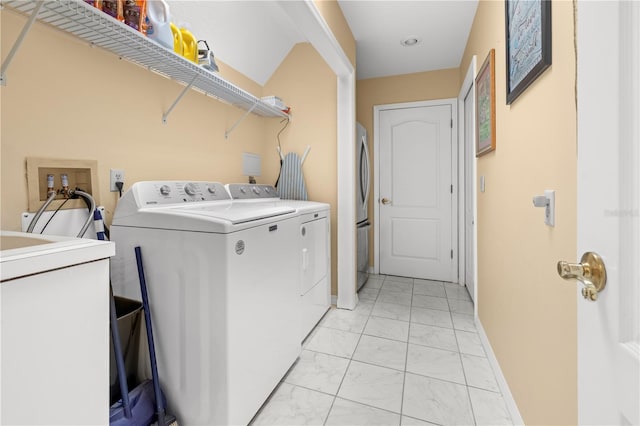 laundry room featuring a sink, baseboards, independent washer and dryer, and laundry area