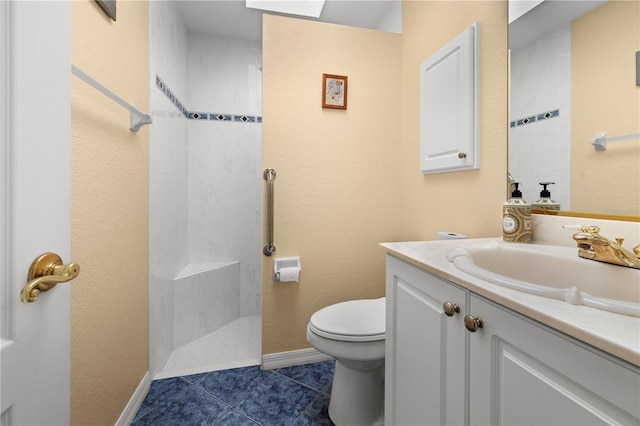 bathroom with tile patterned flooring, baseboards, toilet, a tile shower, and vanity