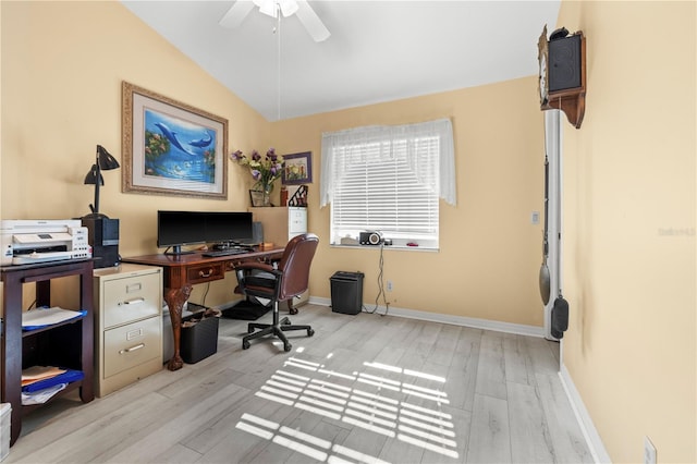 office area featuring vaulted ceiling, light wood-style flooring, a ceiling fan, and baseboards