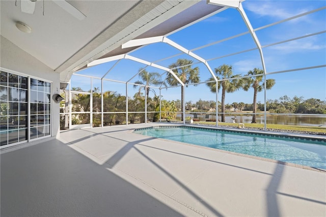 outdoor pool featuring glass enclosure and a patio area