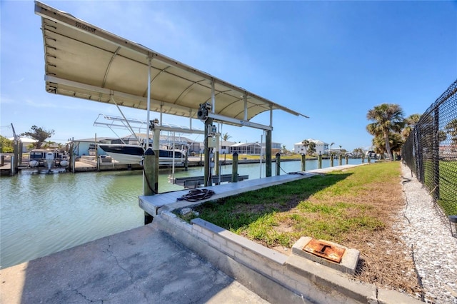 view of dock with a water view, fence, and boat lift