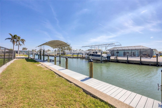 view of dock with a water view, boat lift, and a lawn