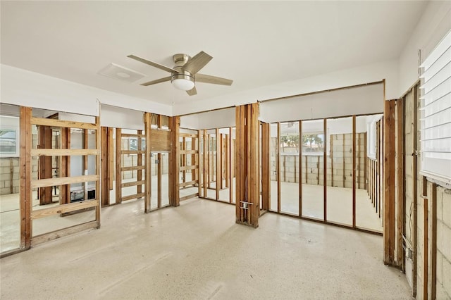 interior space with ceiling fan and speckled floor