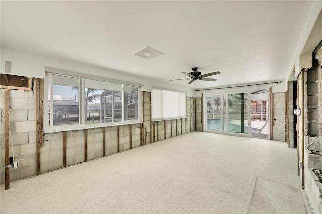 unfurnished sunroom featuring a healthy amount of sunlight and ceiling fan