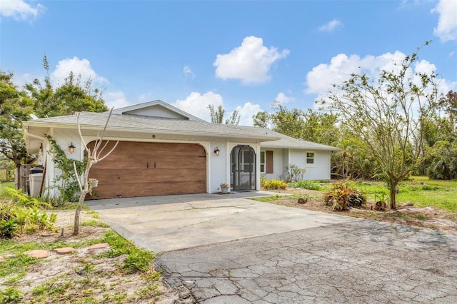 ranch-style home with driveway, an attached garage, and stucco siding