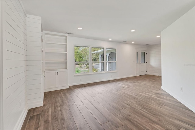 spare room featuring baseboards, wood finished floors, visible vents, and recessed lighting