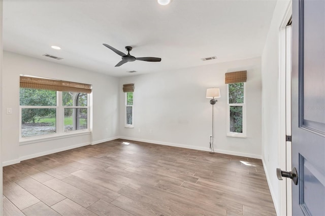 spare room with ceiling fan, wood finished floors, visible vents, and baseboards