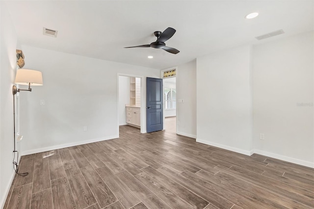 unfurnished bedroom featuring wood finished floors, visible vents, and baseboards