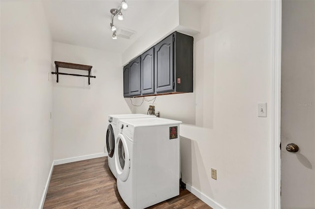 laundry area featuring cabinet space, washer and clothes dryer, baseboards, and wood finished floors