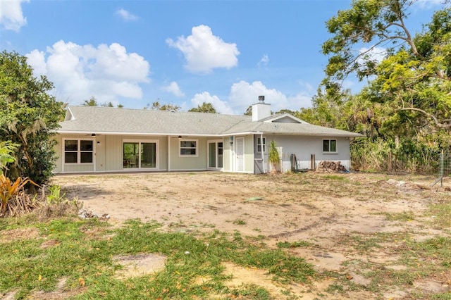 rear view of property featuring a ceiling fan and a chimney