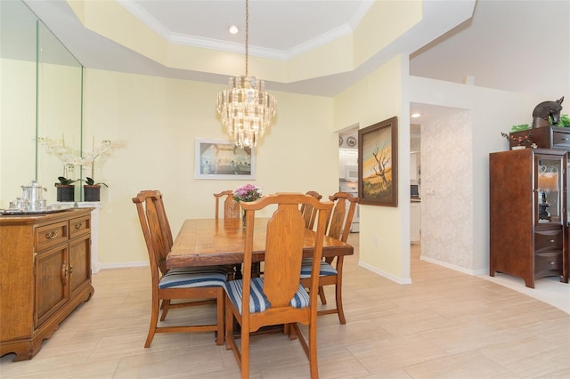 dining space with baseboards, a chandelier, a raised ceiling, and crown molding