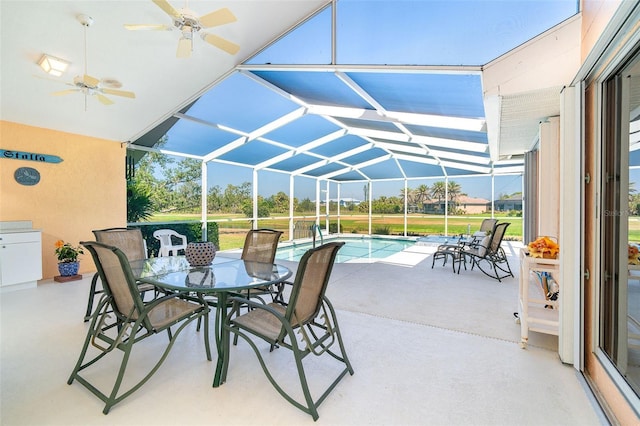 view of patio with outdoor dining space, a lanai, a ceiling fan, and an outdoor pool