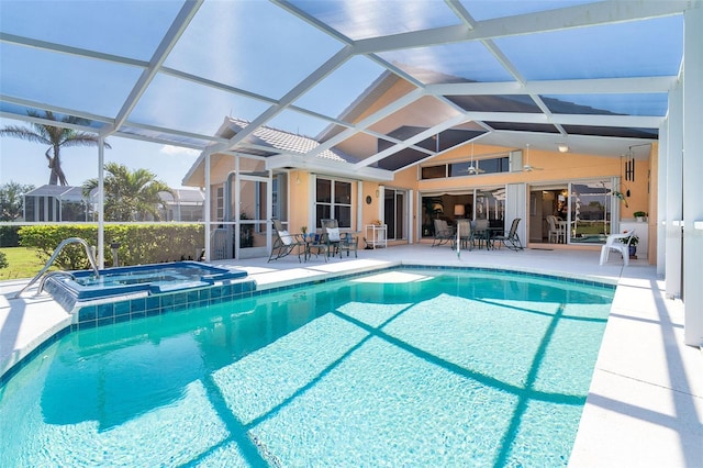 outdoor pool featuring outdoor dining area, glass enclosure, a patio, and an in ground hot tub