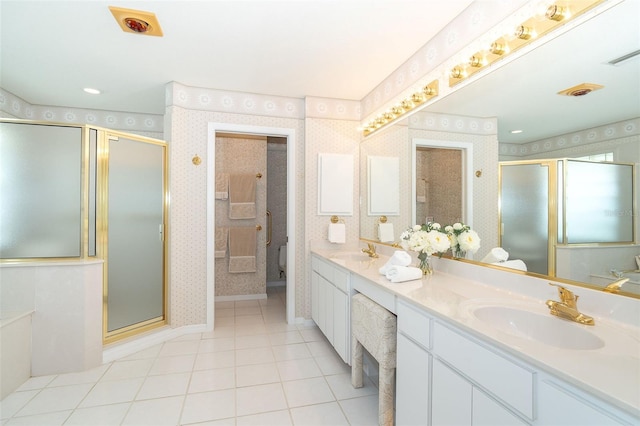 bathroom with a stall shower, a sink, toilet, and wallpapered walls