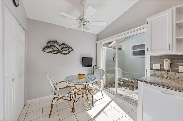 dining room featuring lofted ceiling, baseboards, a ceiling fan, and light tile patterned flooring