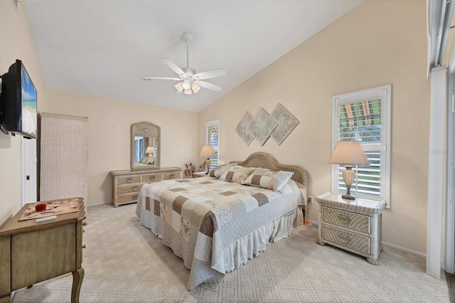 bedroom with lofted ceiling, light colored carpet, ceiling fan, and baseboards