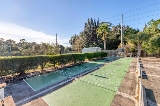 surrounding community with an outbuilding, fence, a storage unit, and shuffleboard