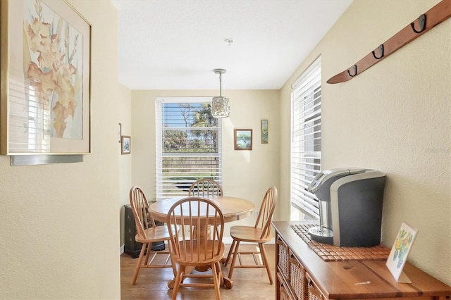 dining space featuring a textured wall and wood finished floors