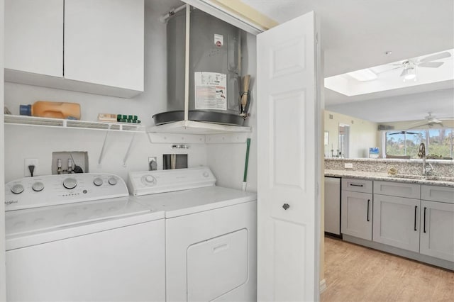 laundry room with washing machine and clothes dryer, ceiling fan, light wood-type flooring, laundry area, and a sink