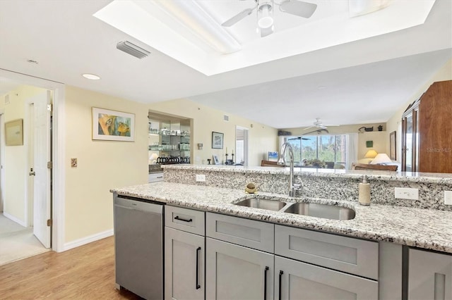 kitchen featuring visible vents, dishwasher, gray cabinetry, and a sink