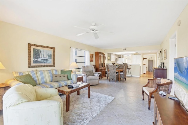 living area featuring light tile patterned floors and ceiling fan